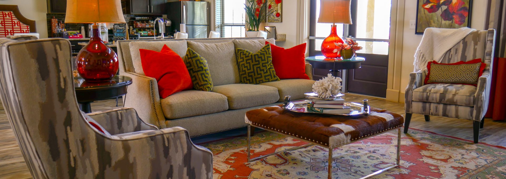 a living room with a red rug and a red couch at The Anatole on MacArthur North