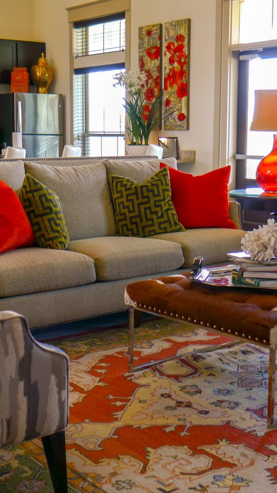 a living room with a red rug and a red couch at The Anatole on MacArthur North