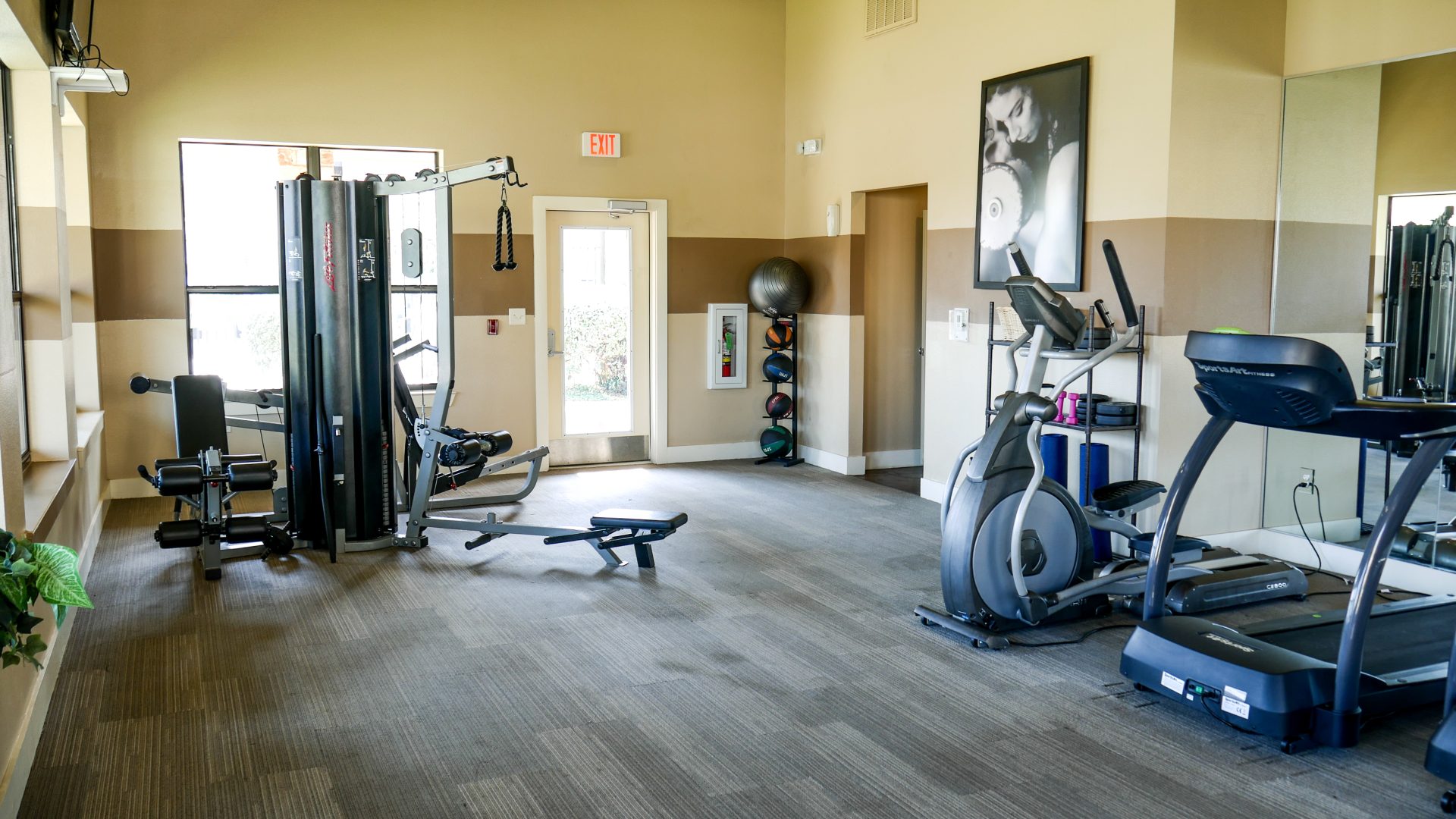 a gym room with exercise equipment and mirrors at The Anatole on MacArthur North