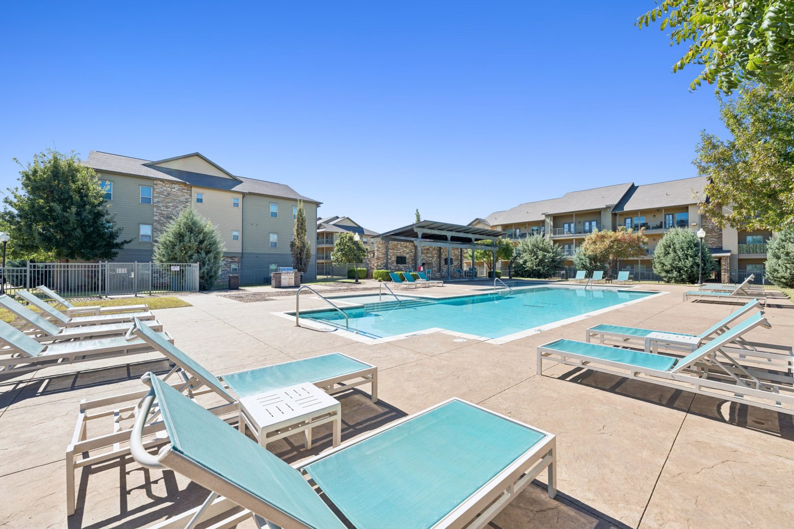 a patio area with chairs, tables, chairs, and umbrellas