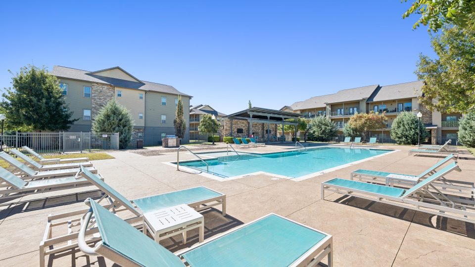 a patio area with chairs, tables, chairs, and umbrellas
